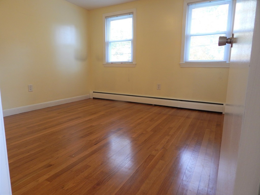 115 Desoto Road Boston, MA 02132 - Photo 13 of 21 an empty room with wooden floor and windows