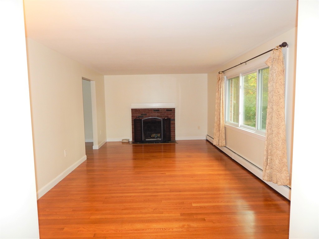 115 Desoto Road Boston, MA 02132 - Photo 3 of 21 a view of empty room with wooden floor and fireplace