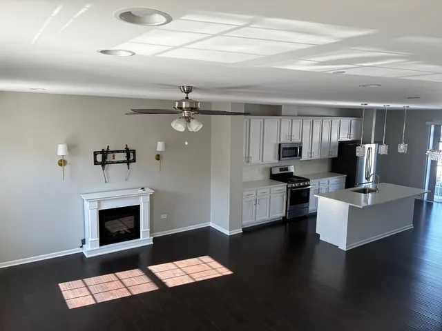 a view of empty room with wooden floor and fireplace