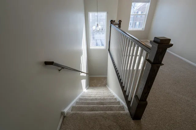a view of an empty room and chandelier fan and a window