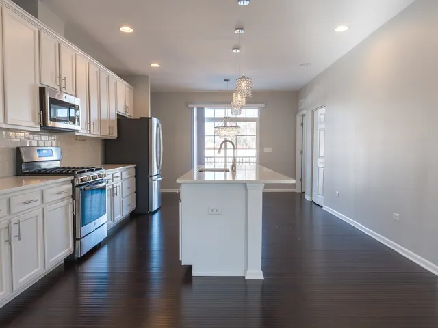 a kitchen with stainless steel appliances granite countertop a sink and a stove