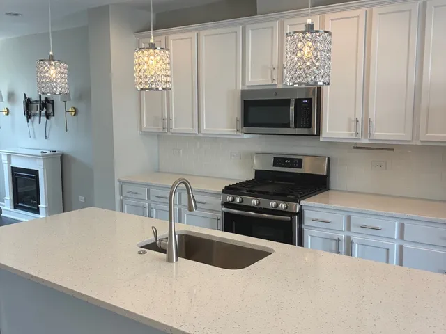 a kitchen that has a sink cabinets and stainless steel appliances