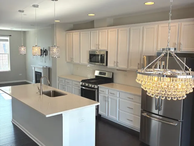 a large kitchen with stainless steel appliances granite countertop a stove a sink and a refrigerator