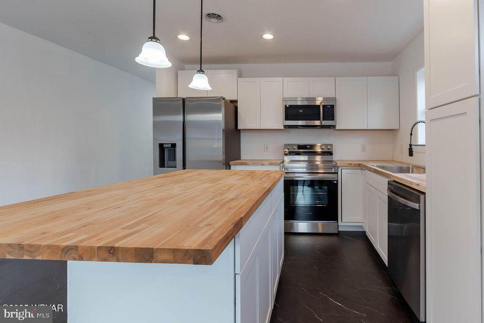 310-312 West Clinton Street Lock Haven, PA 17745 - Photo 15 of 30 a kitchen with stainless steel appliances kitchen island granite countertop a stove a sink and a refrigerator