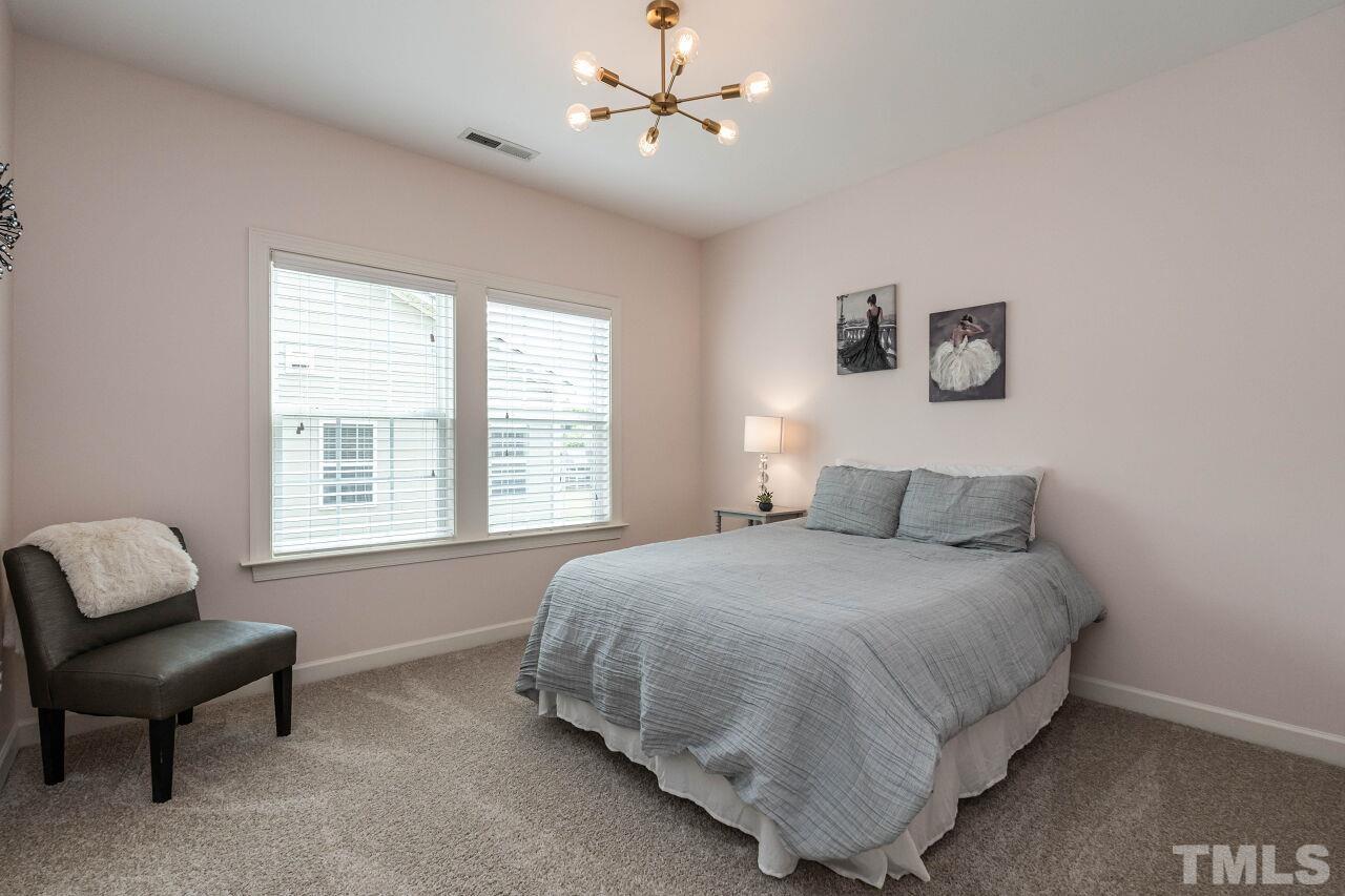 928 Palace Garden Way Raleigh, NC 27603 - Photo 29 of 40 a bedroom with a bed and chair