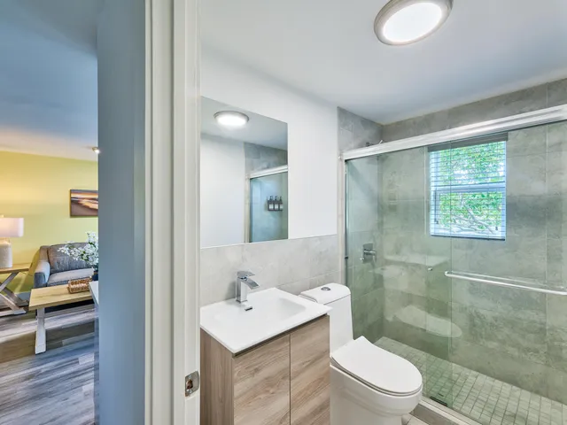 a bathroom with a sink a toilet and shower