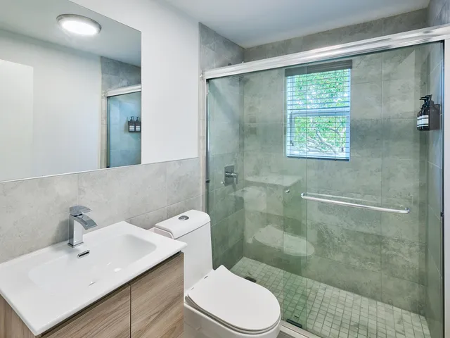 a bathroom with a sink a toilet and shower