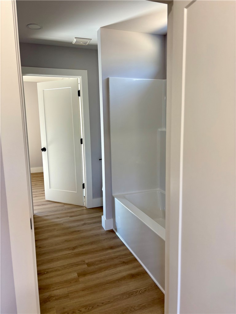 110 Ware Street Seneca, SC 29678 - Photo 16 of 24 This newly renovated bathroom features durable vinyl plank flooring and a modern bathtub, providing a fresh and clean aesthetic.