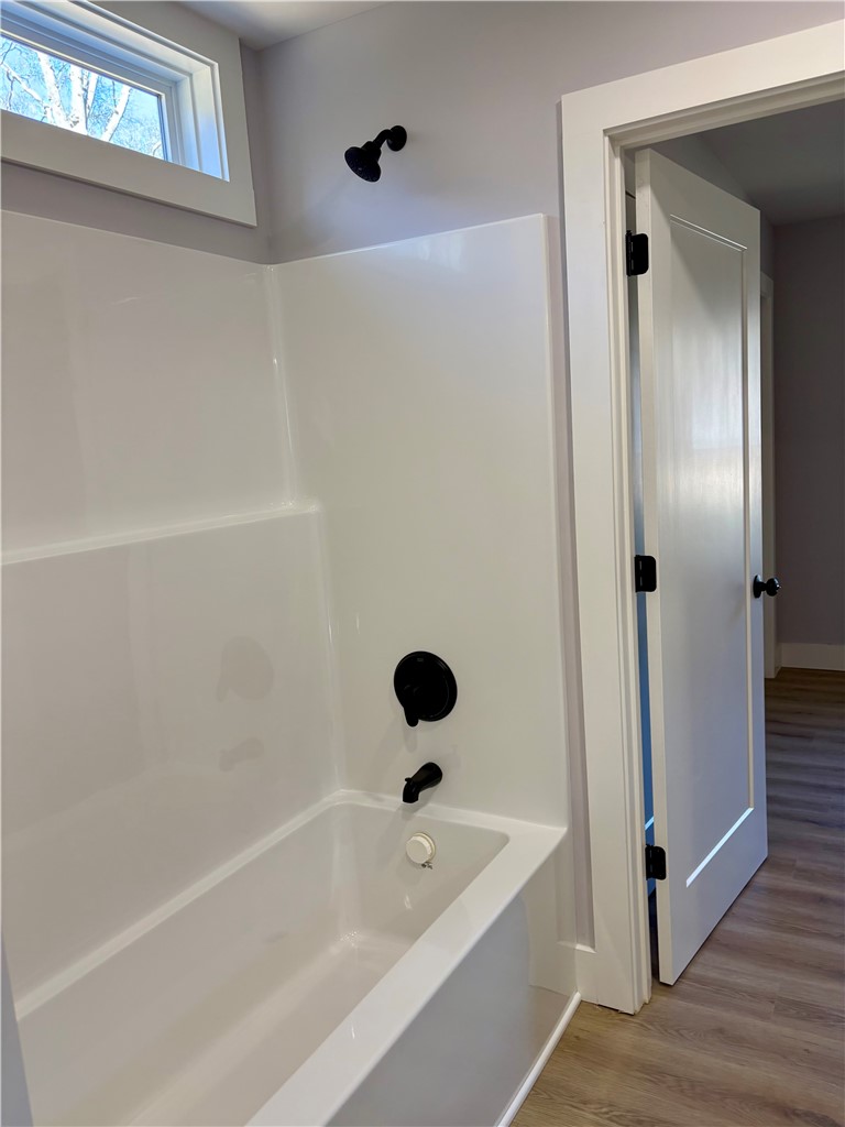110 Ware Street Seneca, SC 29678 - Photo 17 of 24 This bathroom features a contemporary tub and shower combination with stylish black fixtures.