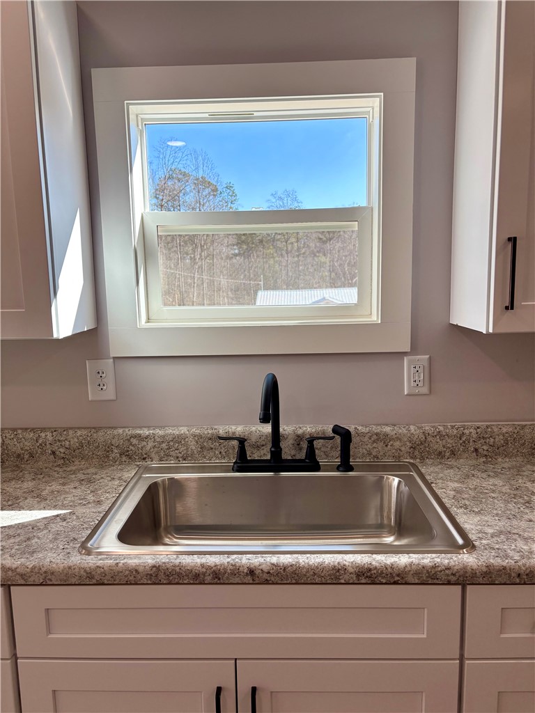 110 Ware Street Seneca, SC 29678 - Photo 21 of 24 This bright kitchen features a functional sink area beneath a large window.