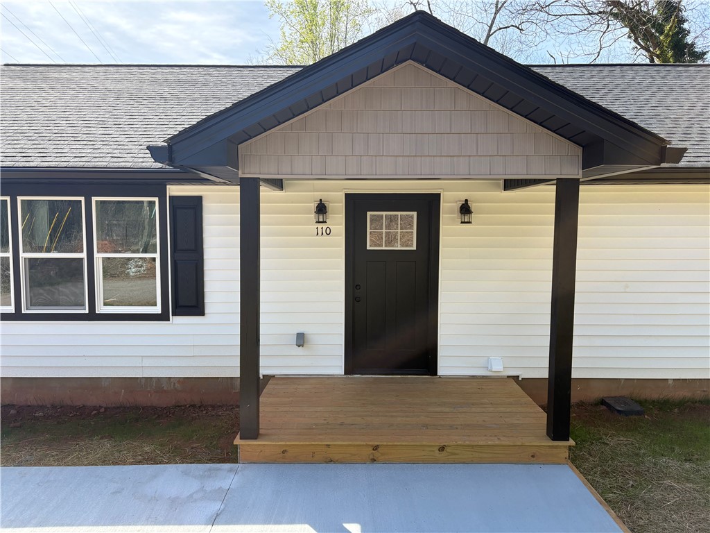 110 Ware Street Seneca, SC 29678 - Photo 4 of 24 Welcome to this inviting residence featuring a charming covered porch and sleek black shutters.