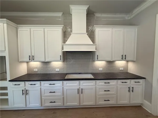 a kitchen with stainless steel appliances granite countertop a sink a stove and a wooden floors