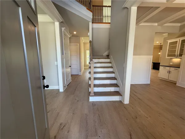 a view of a hallway with wooden floor and stairs
