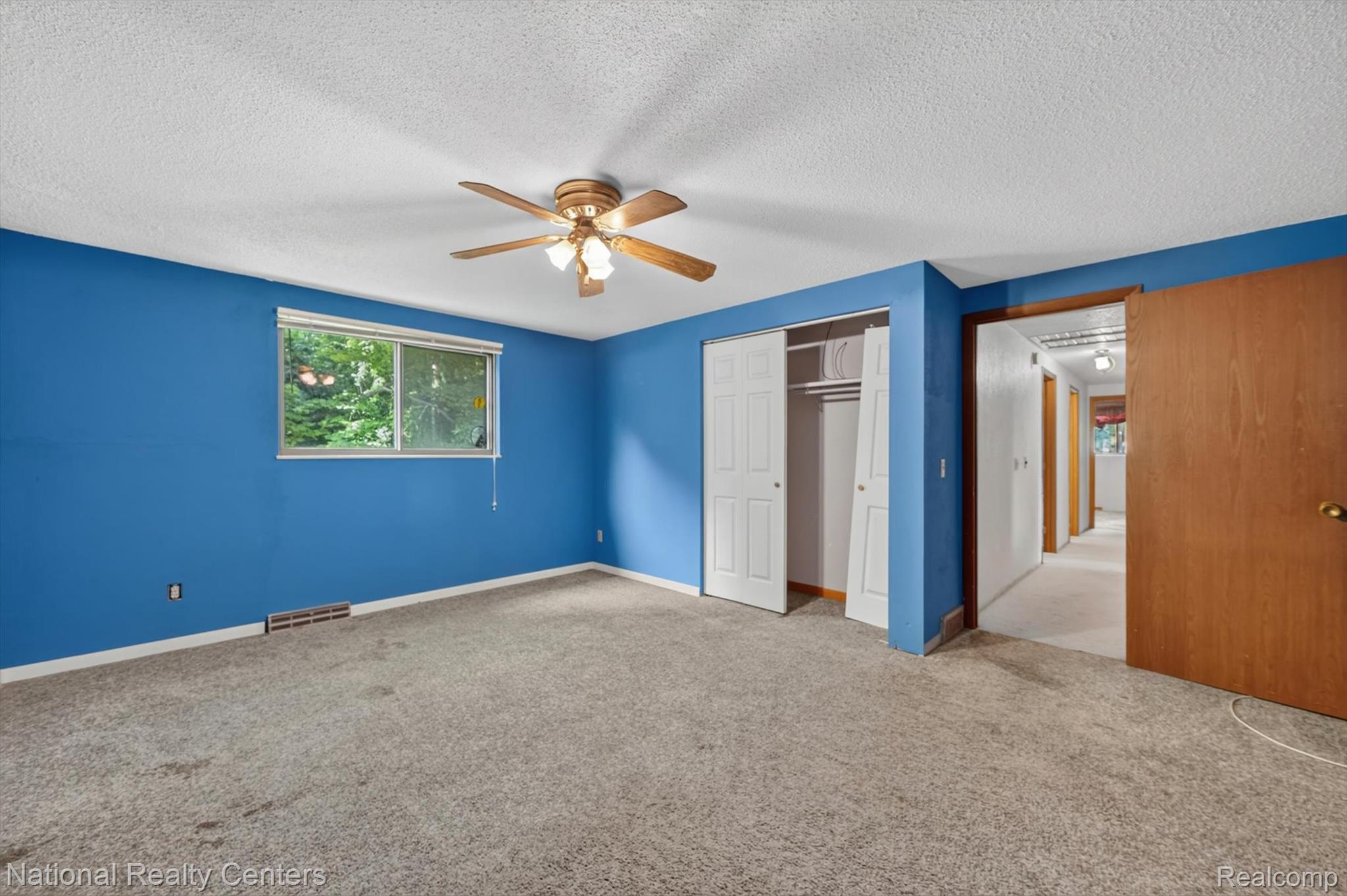 3107 Dean Road Lambertville, MI 48144 - Photo 40 of 45 Spacious room featuring carpet flooring, a window offering natural light, a ceiling fan with integrated lighting, and a bi-fold door closet