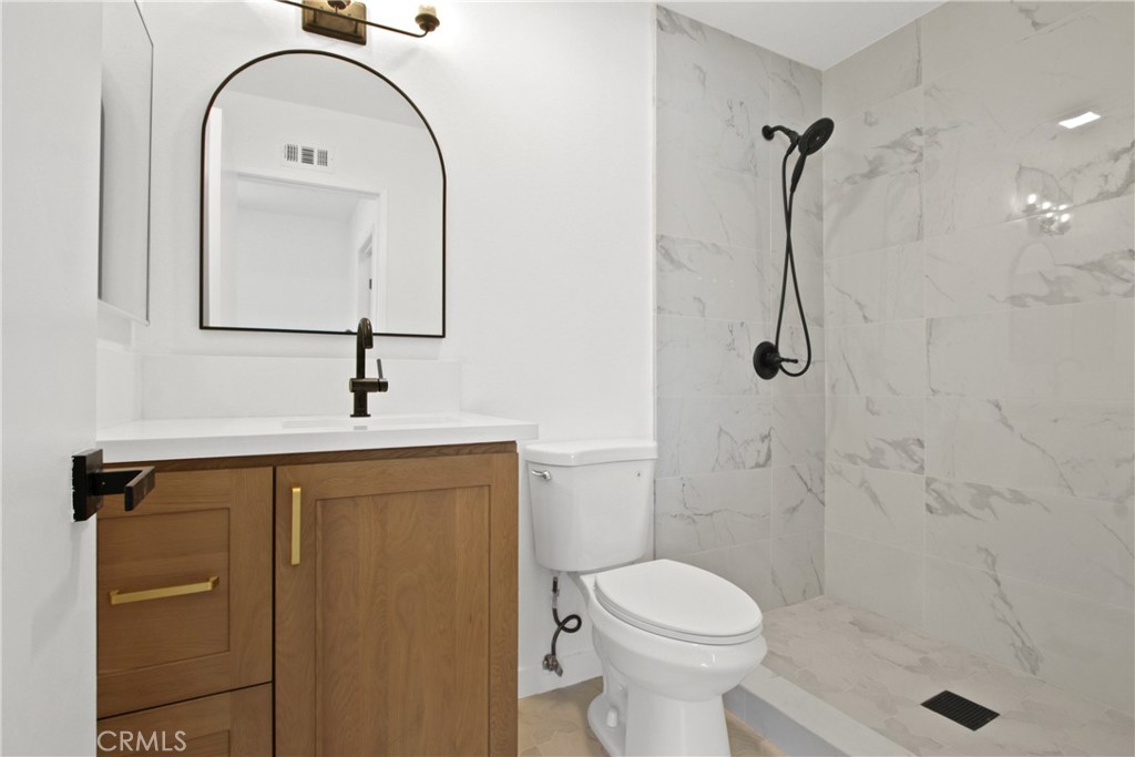 4635 Beach Boulevard Buena Park, CA 90621 - Photo 9 of 32 a bathroom with a sink a toilet and a mirror