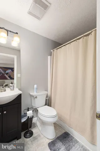 a bathroom with a toilet a sink and a mirror