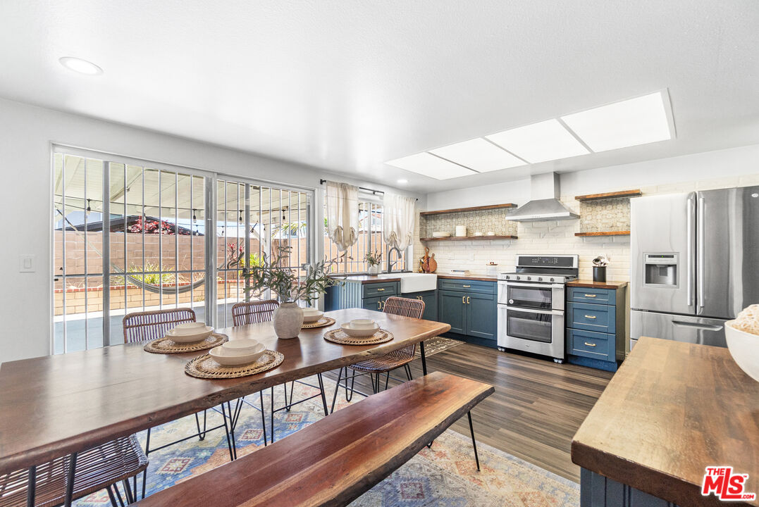 24613 Neptune Avenue Carson, CA 90745 - Photo 13 of 33 a open dining room with stainless steel appliances kitchen island granite countertop a table chairs and a view of living room