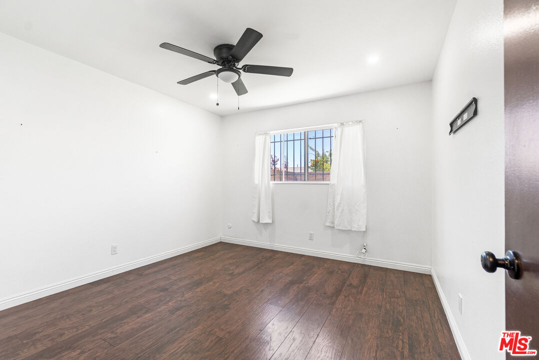 24613 Neptune Avenue Carson, CA 90745 - Photo 25 of 33 an empty room with wooden floor ceiling fan and windows