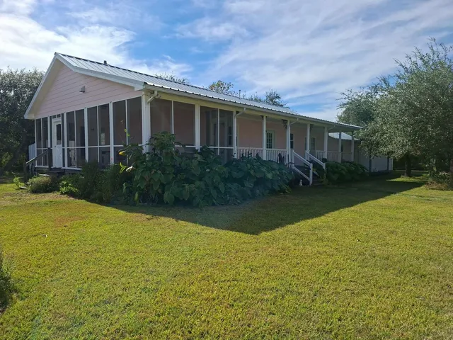 a view of a house with backyard and garden