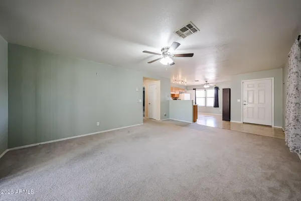 an empty room with a ceiling fan and a window