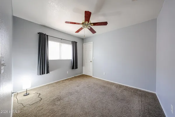 an empty room with windows and fan