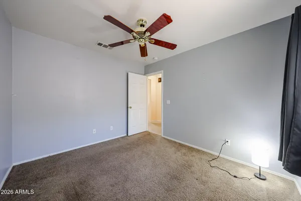 an empty room with windows and ceiling fan