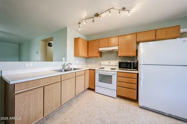 a kitchen with granite countertop a sink appliances cabinets and counter space