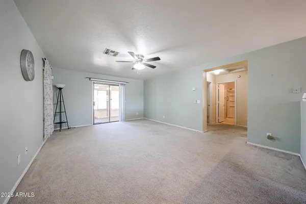 a view of empty room with windows and ceiling fan