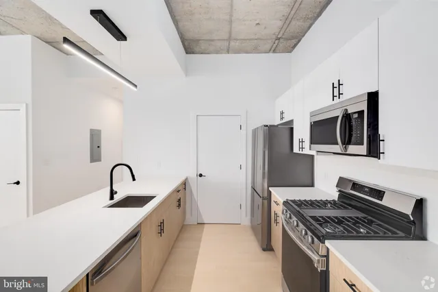 a kitchen with stainless steel appliances kitchen island a sink stove and refrigerator