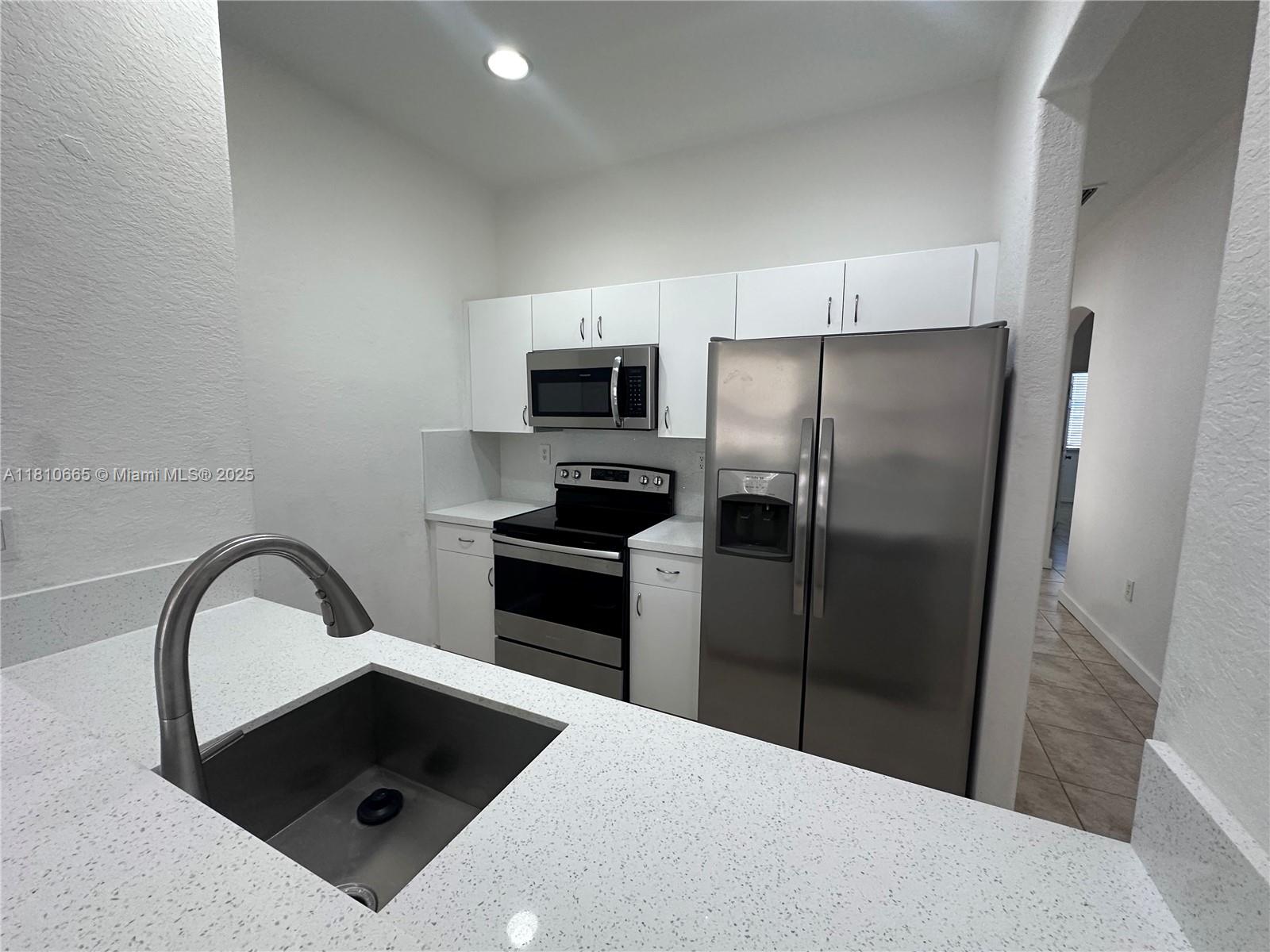 11014 Southwest 237th Lane Homestead, FL 33032 - Photo 11 of 47 a kitchen with a refrigerator sink and microwave