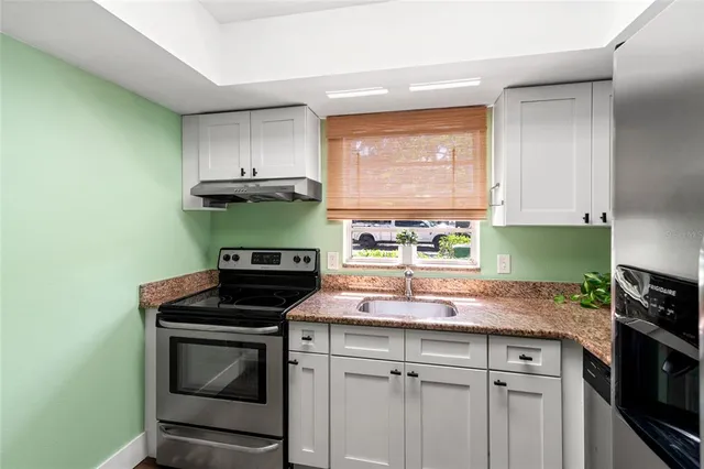 a kitchen with kitchen island granite countertop stainless steel appliances a stove and a microwave