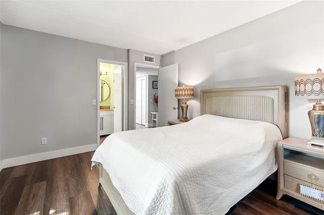 a large bed sitting in a bedroom next to a window and a wooden floor