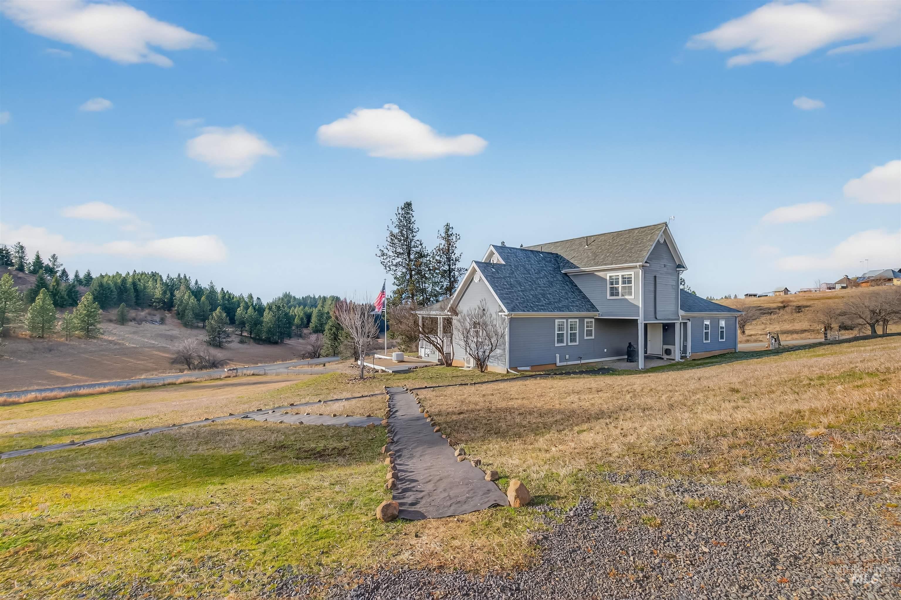 108 Tweedy Lane Kooskia, ID 83539 - Photo 12 of 48 View of side of property featuring a yard and a shingled roof