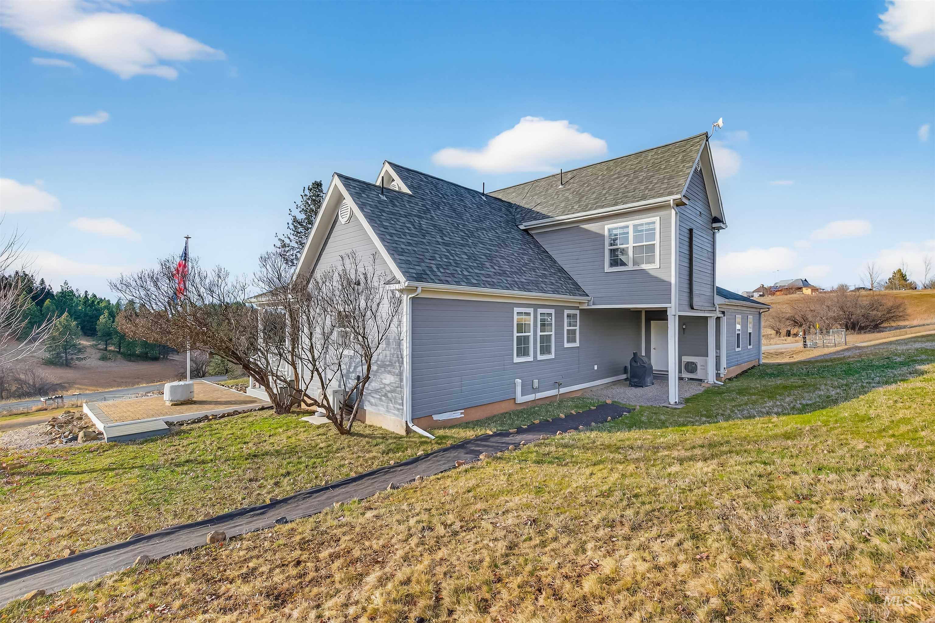 108 Tweedy Lane Kooskia, ID 83539 - Photo 13 of 48 View of home's exterior with a patio, a lawn, and roof with shingles