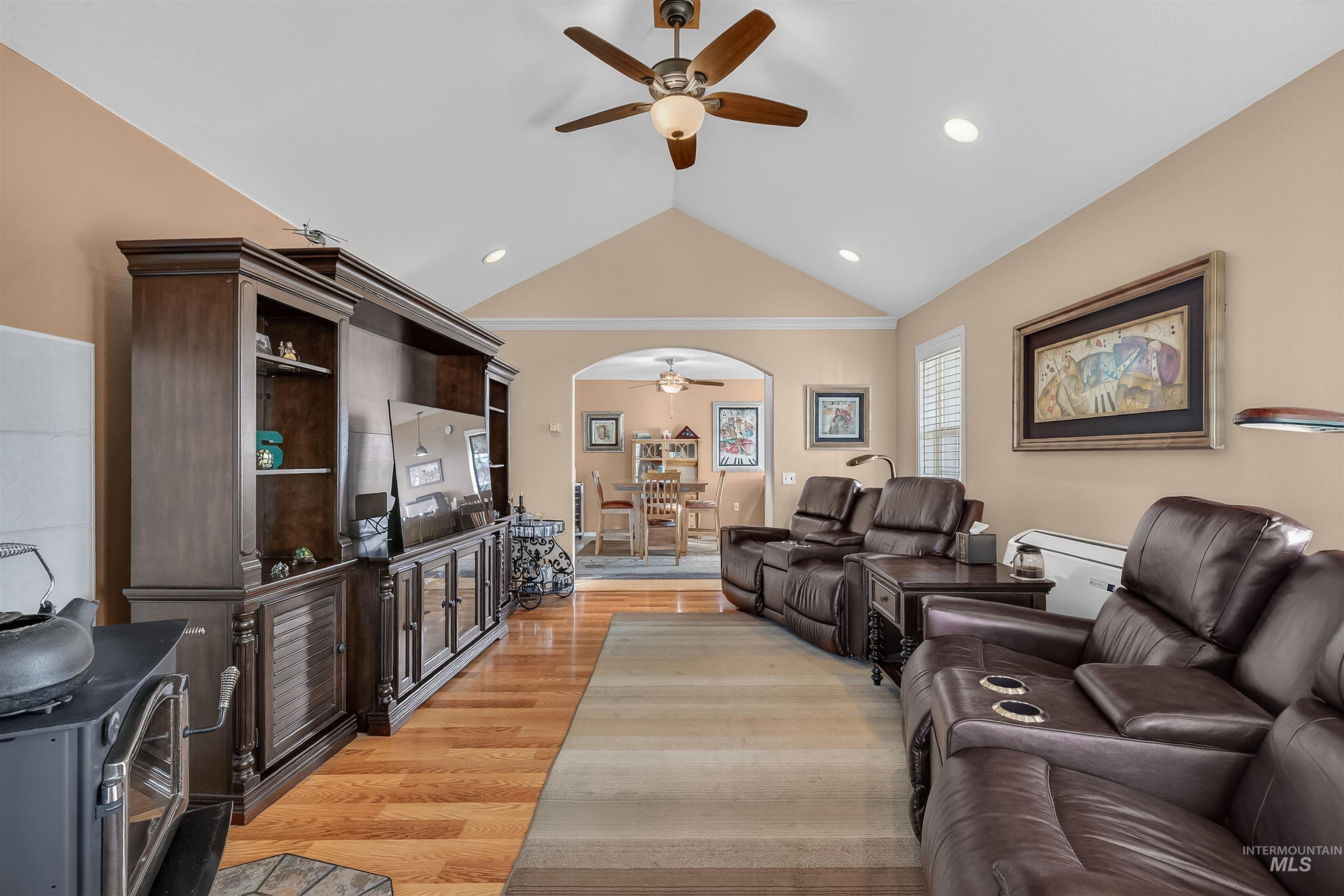 108 Tweedy Lane Kooskia, ID 83539 - Photo 19 of 48 Living room with a ceiling fan, light wood-type flooring, vaulted ceiling, a wood stove, and arched walkways