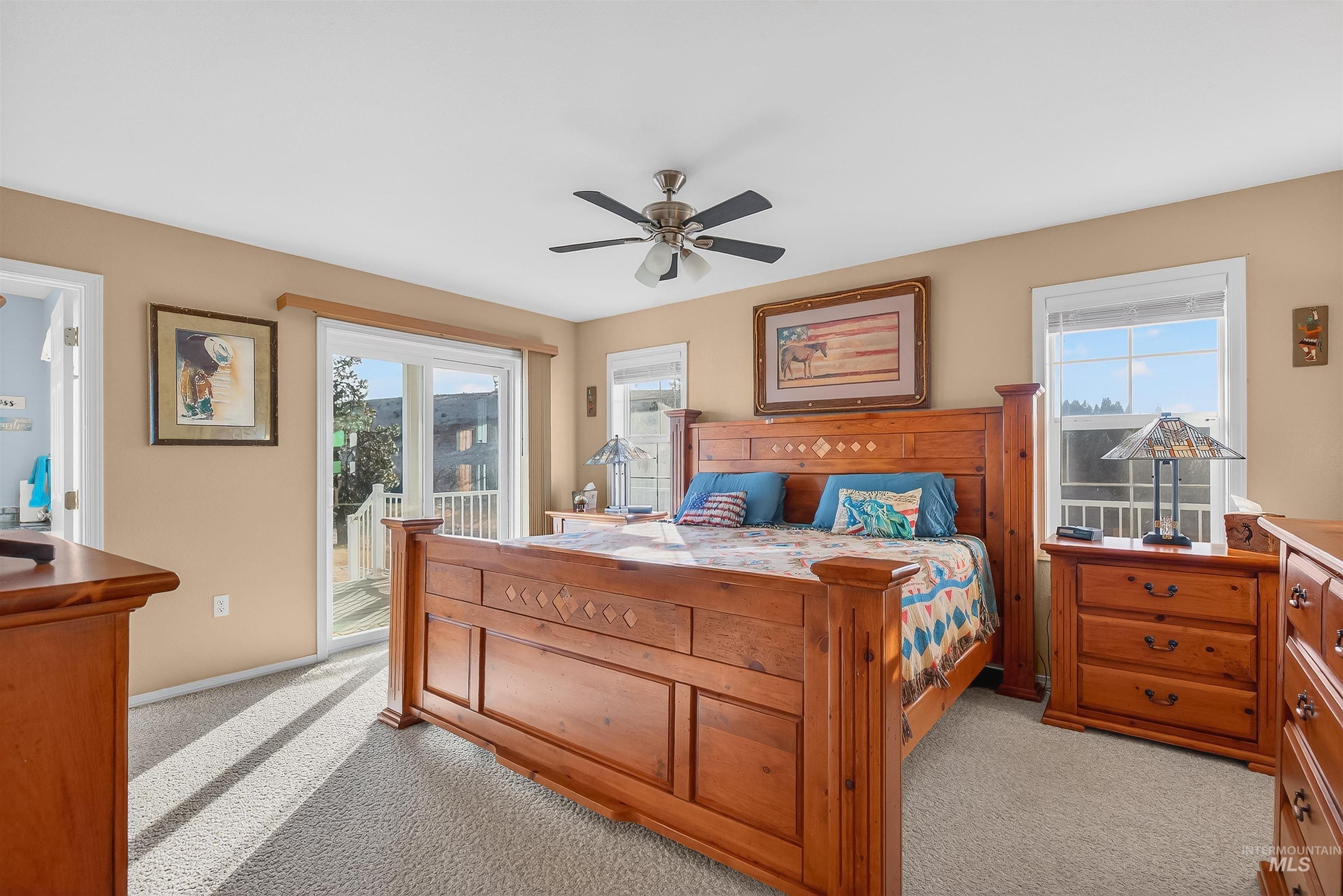 108 Tweedy Lane Kooskia, ID 83539 - Photo 29 of 48 Bedroom with light colored carpet, multiple windows, access to outside, and a ceiling fan