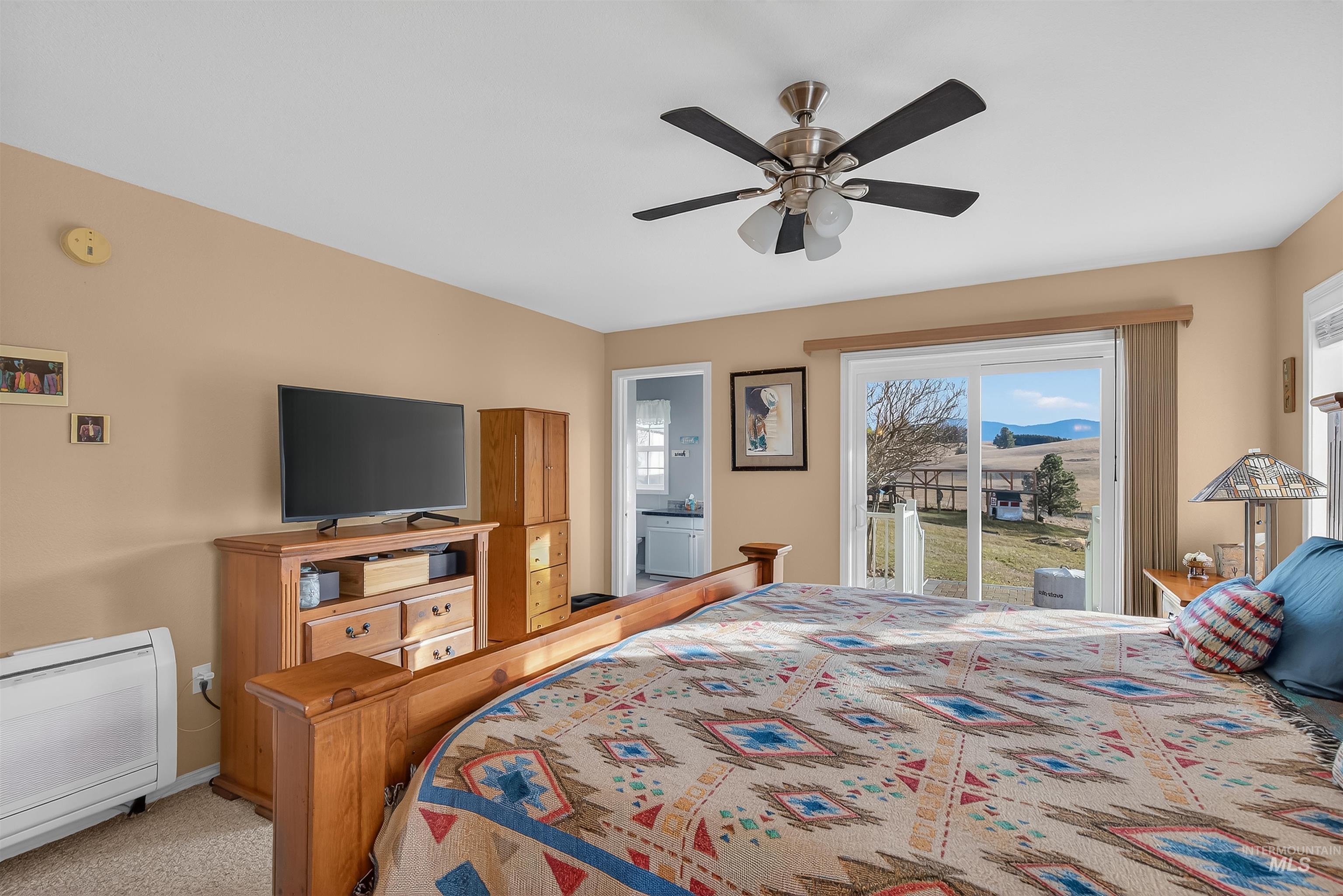 108 Tweedy Lane Kooskia, ID 83539 - Photo 30 of 48 Bedroom featuring access to exterior, a ceiling fan, light colored carpet, and ensuite bath