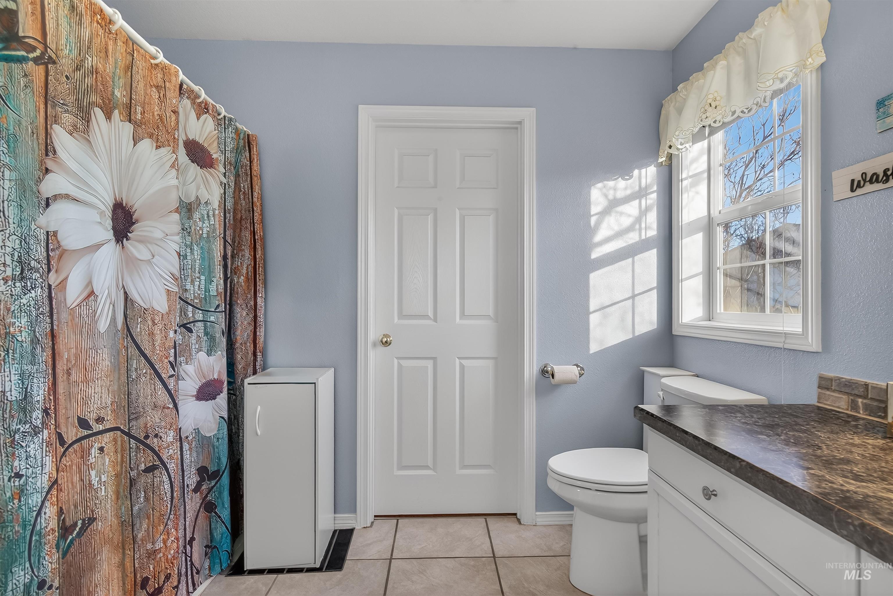 108 Tweedy Lane Kooskia, ID 83539 - Photo 33 of 48 Bathroom featuring a shower with shower curtain, vanity, and light tile patterned flooring