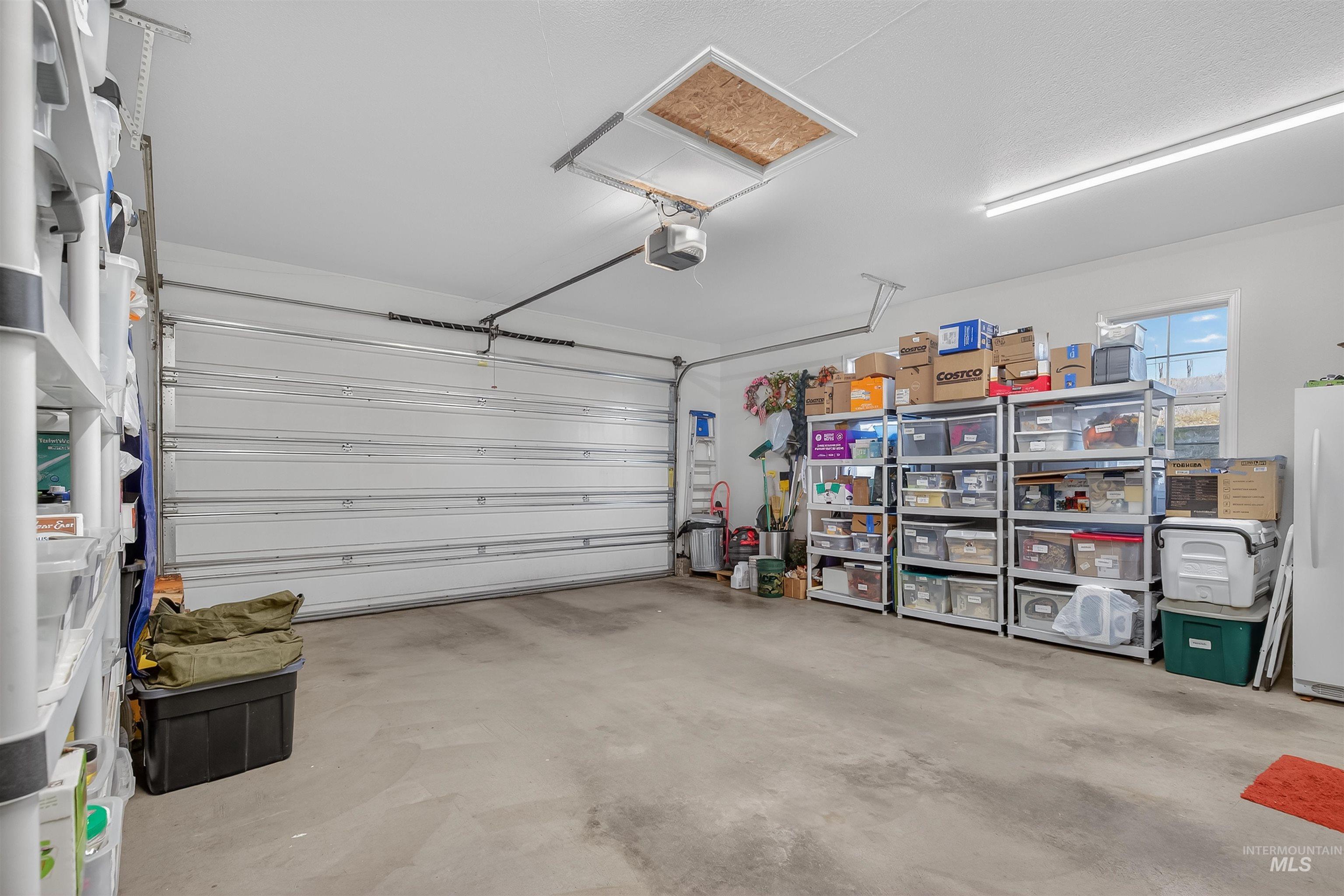 108 Tweedy Lane Kooskia, ID 83539 - Photo 39 of 48 Garage with freestanding refrigerator and a garage door opener