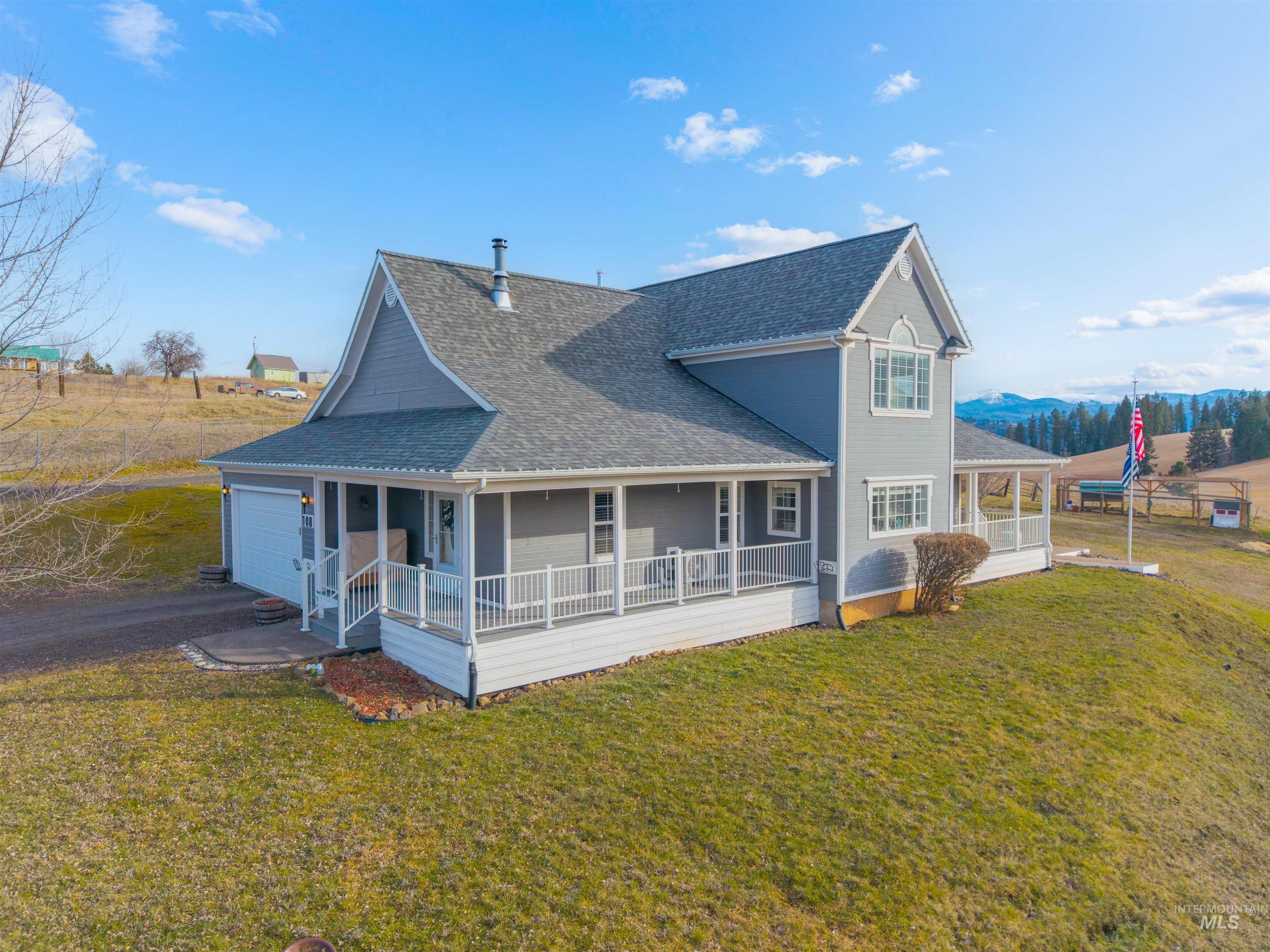 108 Tweedy Lane Kooskia, ID 83539 - Photo 40 of 48 Back of house with a shingled roof, a large porch, a yard, driveway, and a garage
