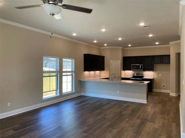 a view of a living room with kitchen view and wooden floor