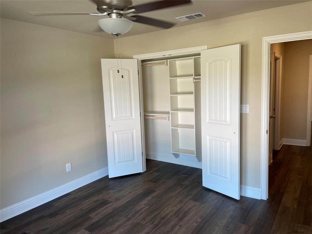 634 Nolan Drive Sherman, TX 75092 - Photo 6 of 18 an empty room with wooden floor a ceiling fan and windows