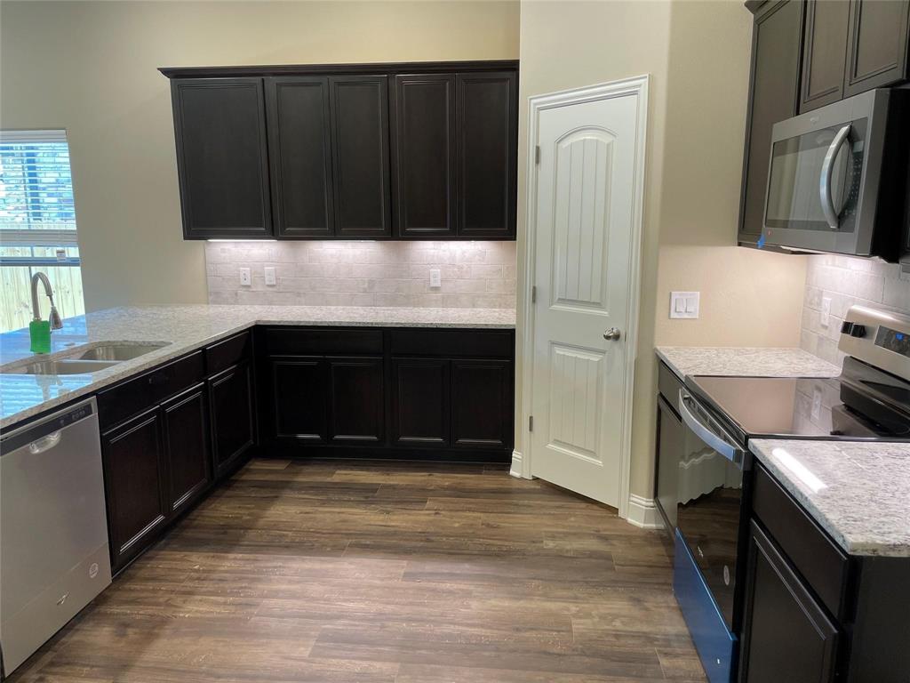 634 Nolan Drive Sherman, TX 75092 - Photo 9 of 18 a kitchen with stainless steel appliances granite countertop a stove and a refrigerator