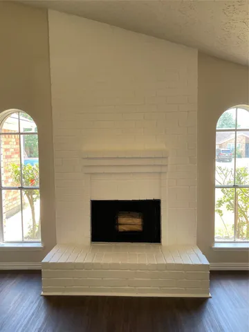 a living room with a fireplace and a large window