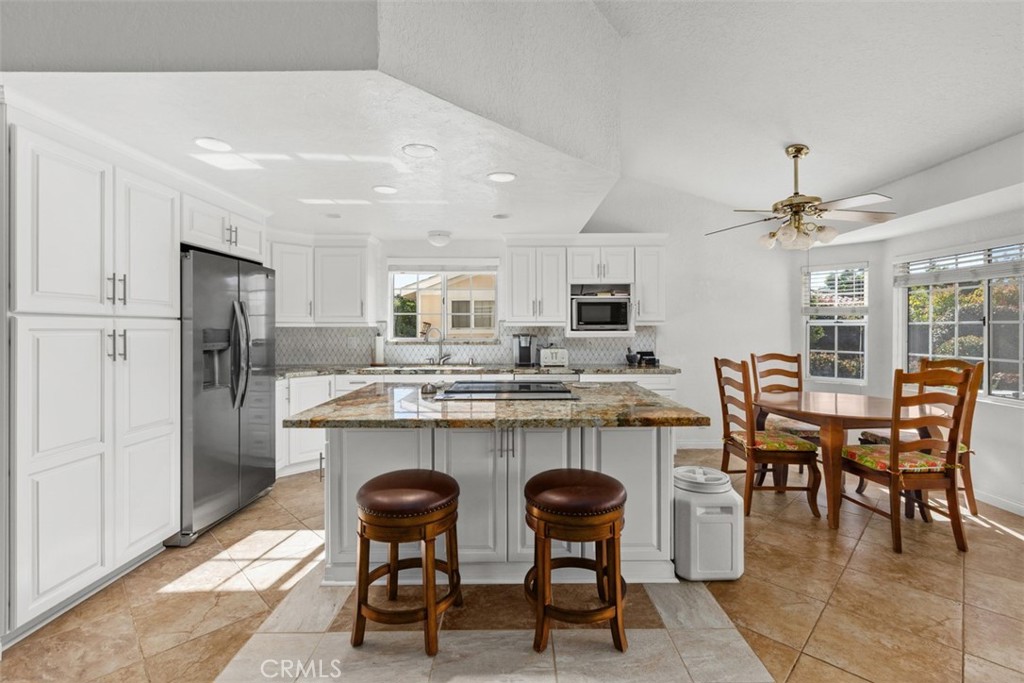 1765 Armadale Road Fallbrook, CA 92028 - Photo 15 of 45 a kitchen with a table chairs refrigerator and cabinets