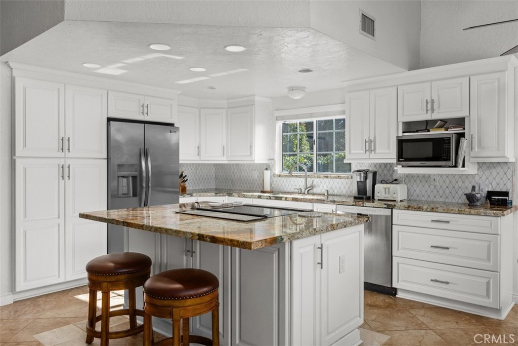 1765 Armadale Road Fallbrook, CA 92028 - Photo 16 of 45 a kitchen with a stove a sink a refrigerator a dining table and chairs