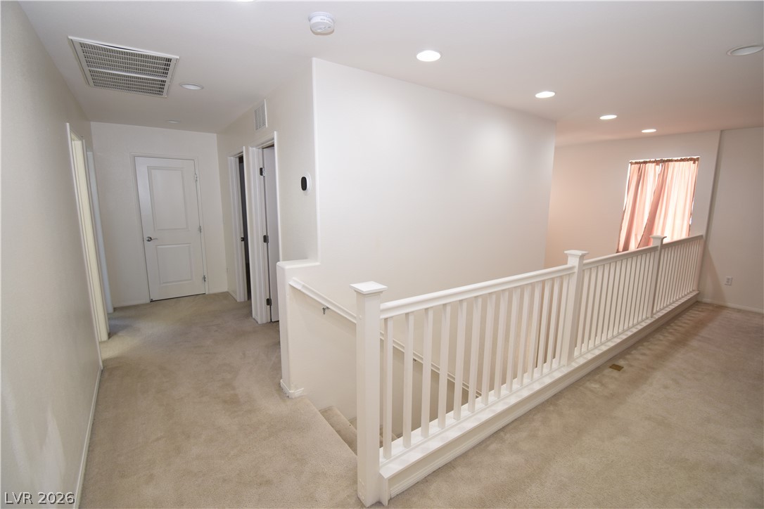 3622 Via Terracina Henderson, NV 89052 - Photo 17 of 22 A well-lit upper landing features soft carpeting and white railing, connecting various rooms.