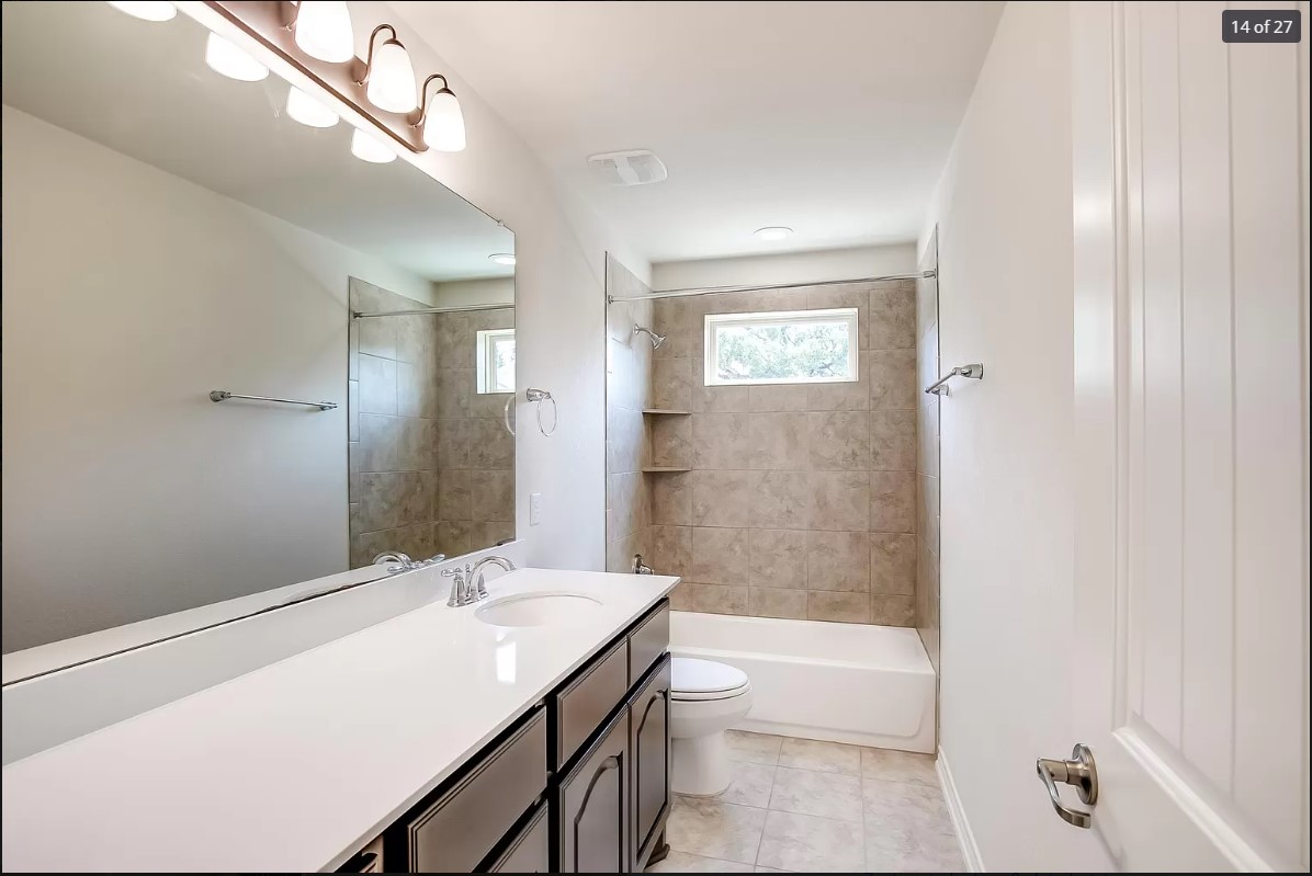 14215 McCoy Loop Austin, TX 78717 - Photo 11 of 27 Bathroom vanity featuring a single basin, chrome faucet, and expansive mirror