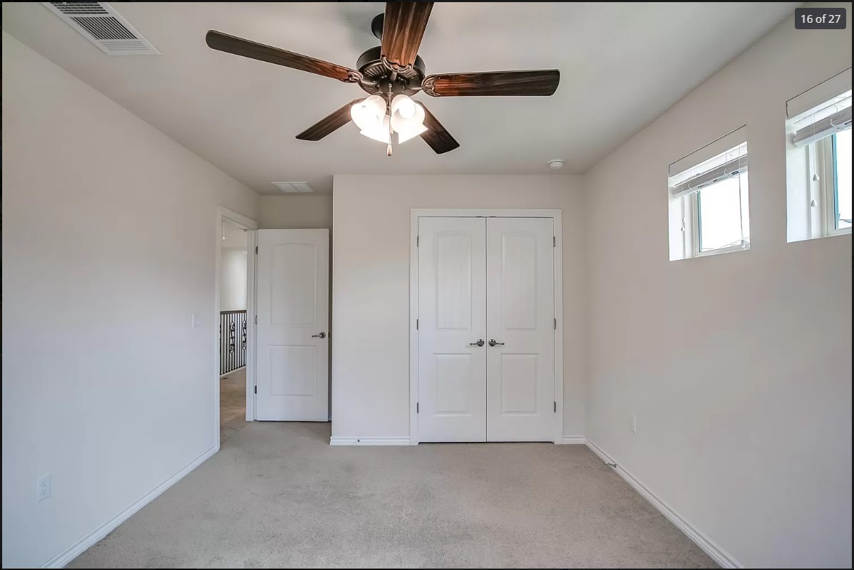 14215 McCoy Loop Austin, TX 78717 - Photo 13 of 27 Carpeted room featuring a ceiling fan with light fixture, two windows with blinds, and white double-panel doors
