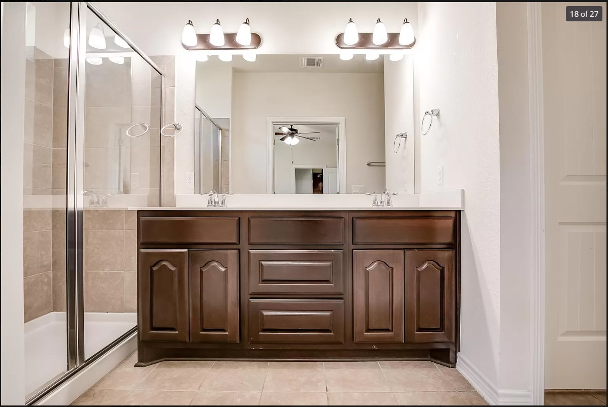 14215 McCoy Loop Austin, TX 78717 - Photo 15 of 27 Bathroom featuring a dual vanity with dark wood cabinetry, white countertops, and dual mirrors